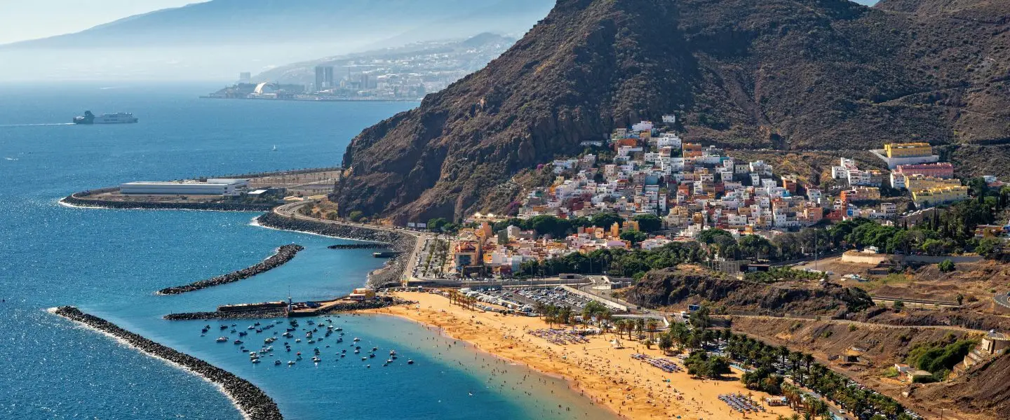 Stunning aerial view of Playa de Las Teresitas in Tenerife with mountainous backdrop.